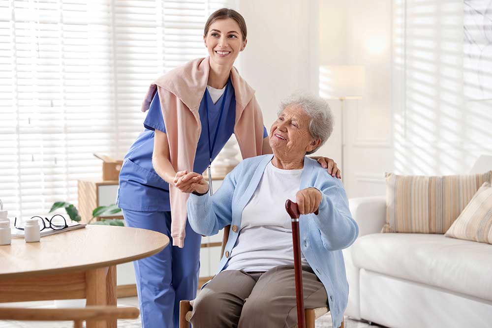 caregiver supporting senior woman indoors home health care service